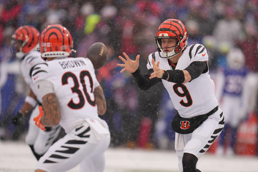 Cincinnati Bengals quarterback Joe Burrow (9) shovels the ball during the first half of an NFL football game against the Buffalo Bills, Sunday, Dec. 7, 2025, in Orchard Park, N.Y. (AP Photo/Gene J. Puskar)