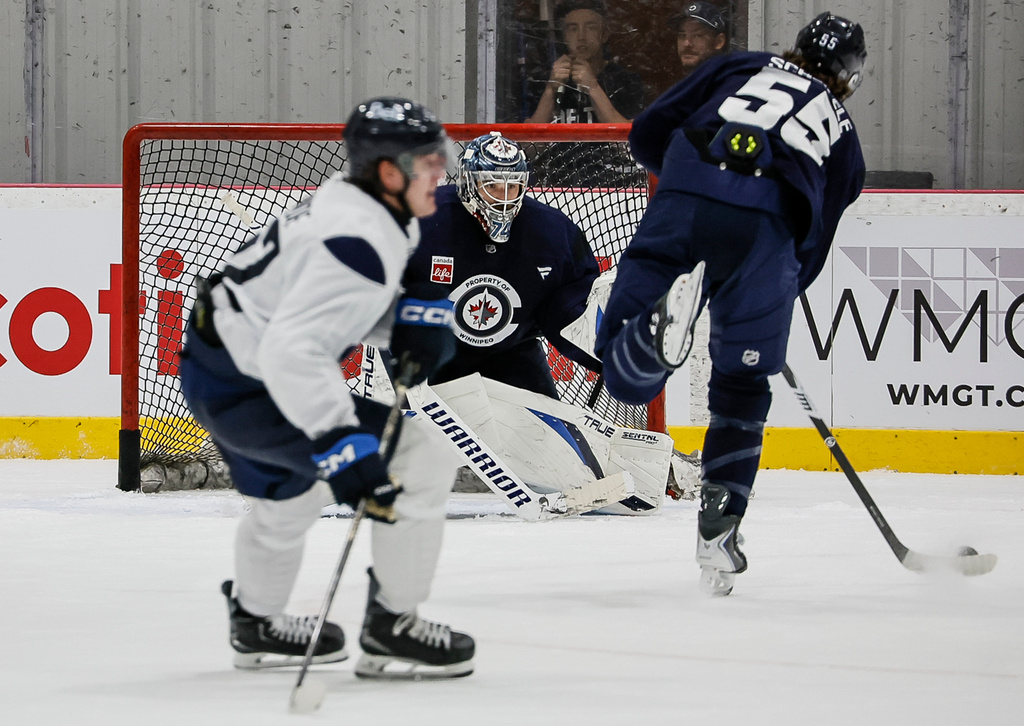 Winnipeg Jets' Mark Scheifele (55) takes a shot on goaltender Stuart Skinner (74) during the NHL hockey team's training camp in Winnipeg, Manitoba, Thursday, Sept. 17, 2026. (John Woods/The Canadian Press via AP)