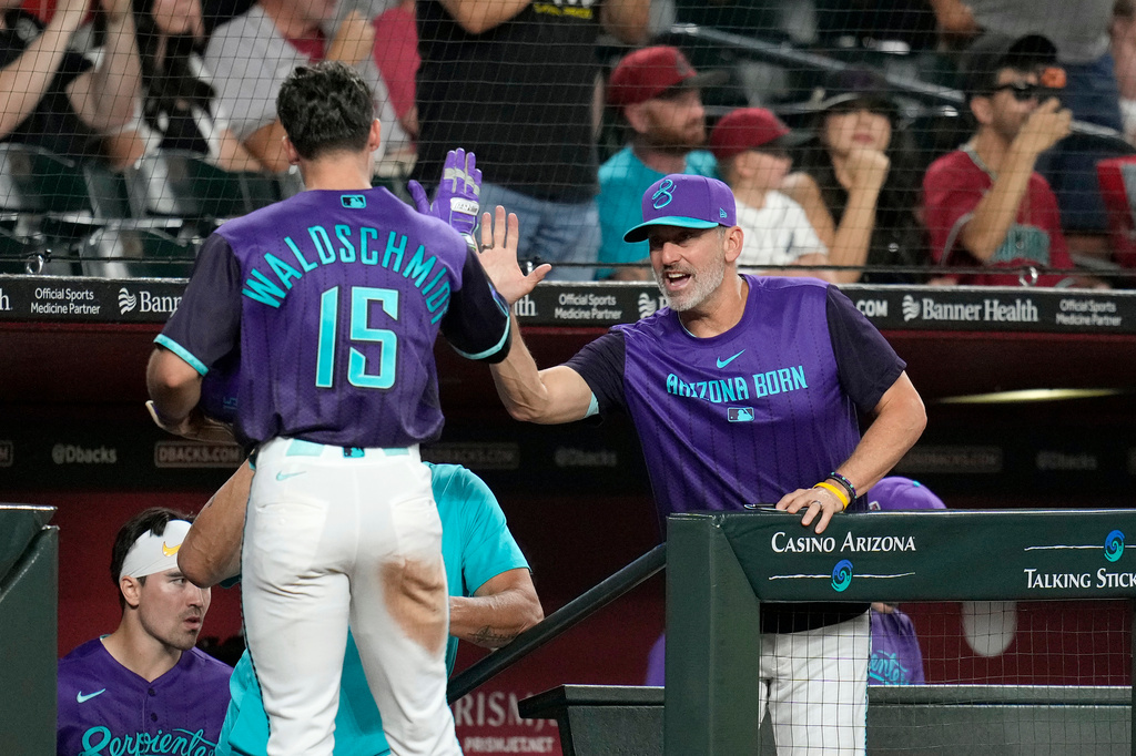 Arizona Diamondbacks manager Torey Lovullo, right, celebrates a run scored by Diamondbacks' Ryan Waldschmidt (15) during the fifth inning of a baseball game, Friday, Sept. 11, 2026, in Phoenix. (AP Photo/Ross D. Franklin)