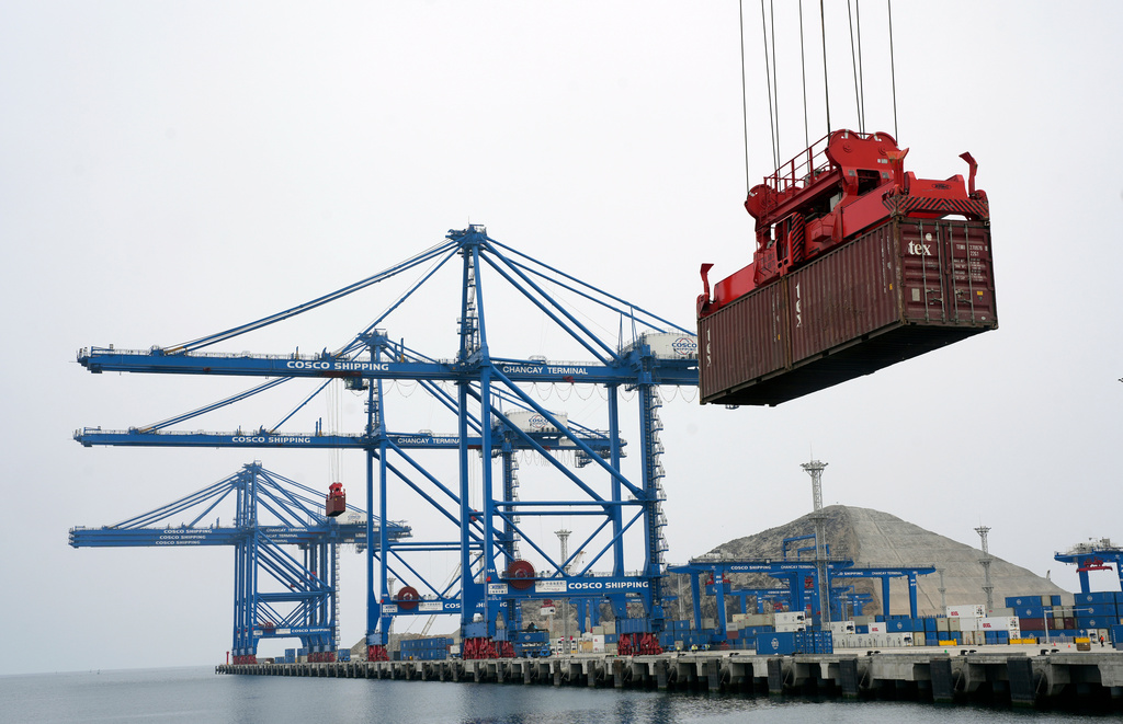 FILE - A container is lifted by a crane backdropped by the construction of the Chinese-funded port, in Chancay, Peru, Oct. 29, 2024. (AP Photo/Guadalupe Pardo, File)