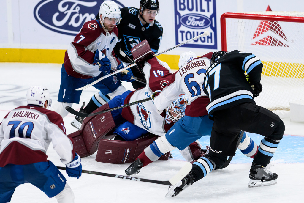 Colorado Avalanche goaltender Scott Wedgewood, center, makes a diving save to stop the shot of Utah Mammoth left wing Lawson Crouse, right, during the third period of an NHL hockey game, Wednesday, Feb. 25, 2026, in Salt Lake City. (AP Photo/Tyler Tate)