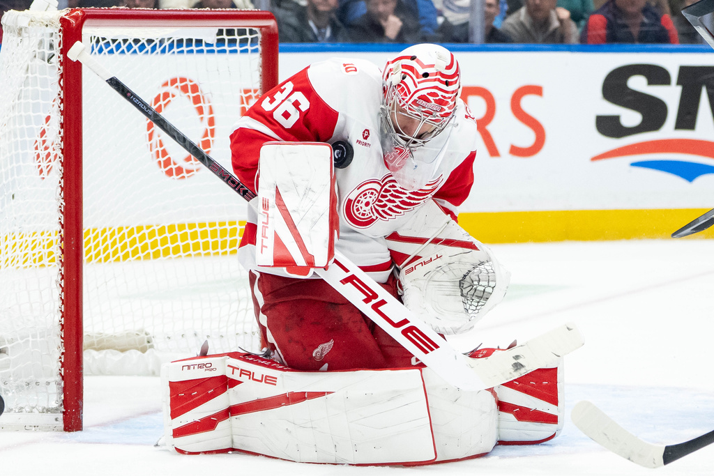 Detroit Red Wings goaltender John Gibson (36) stops the puck against the Vancouver Canucks during the third period of an NHL hockey game in Vancouver, B.C., Monday, Dec. 8, 2025. (Ethan Cairns/The Canadian Press via AP)