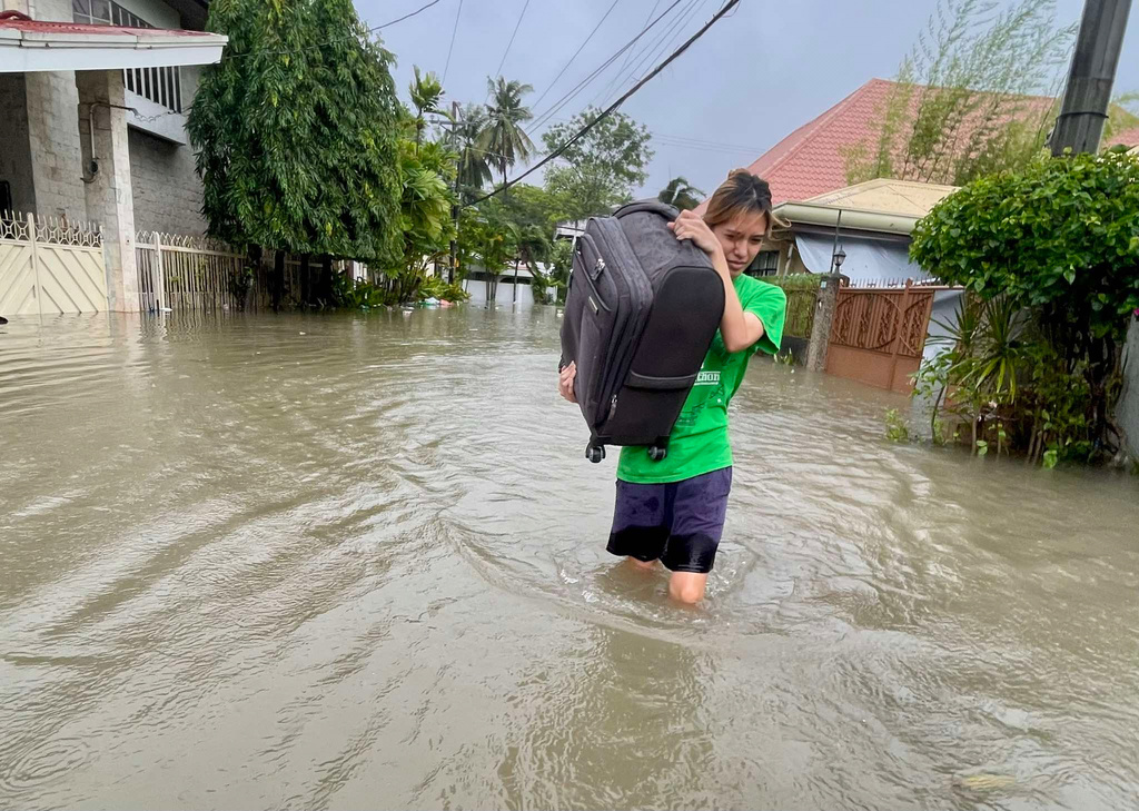 A resident navigates a flooded street as they evacuate to safer grounds as Typhoon Kalmaegi affects Cebu city, central Philippines, Tuesday Nov. 4, 2025. (AP Photo/Jacqueline Hernandez)
