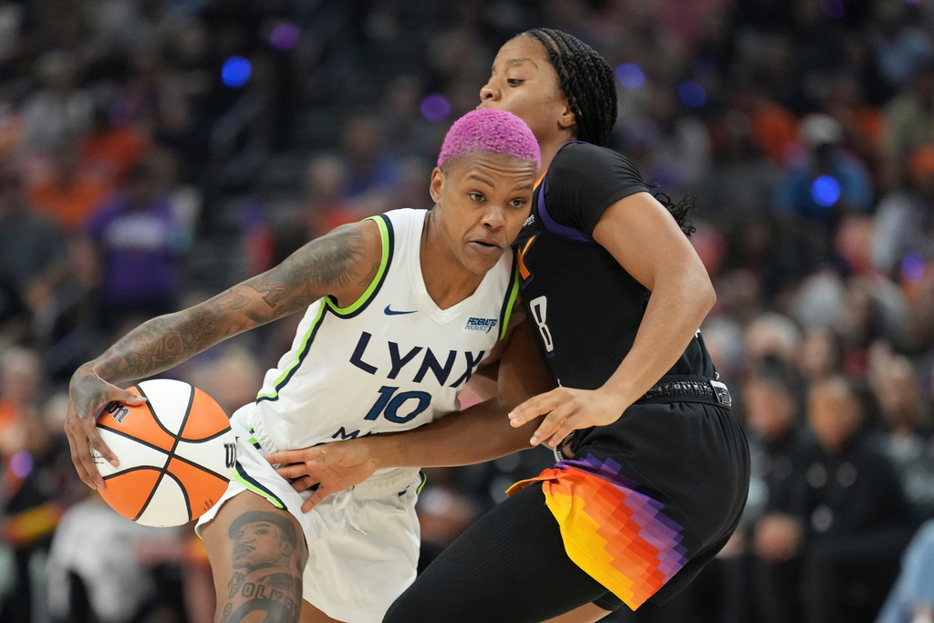 Minnesota Lynx guard Courtney Williams (10) dribbles past Phoenix Mercury guard Monique Akoa Makani (8) during the first half of Game 3 of a WNBA basketball playoff semifinals series game Friday, Sept. 26, 2025, in Phoenix. (AP Photo/Ross D. Franklin)