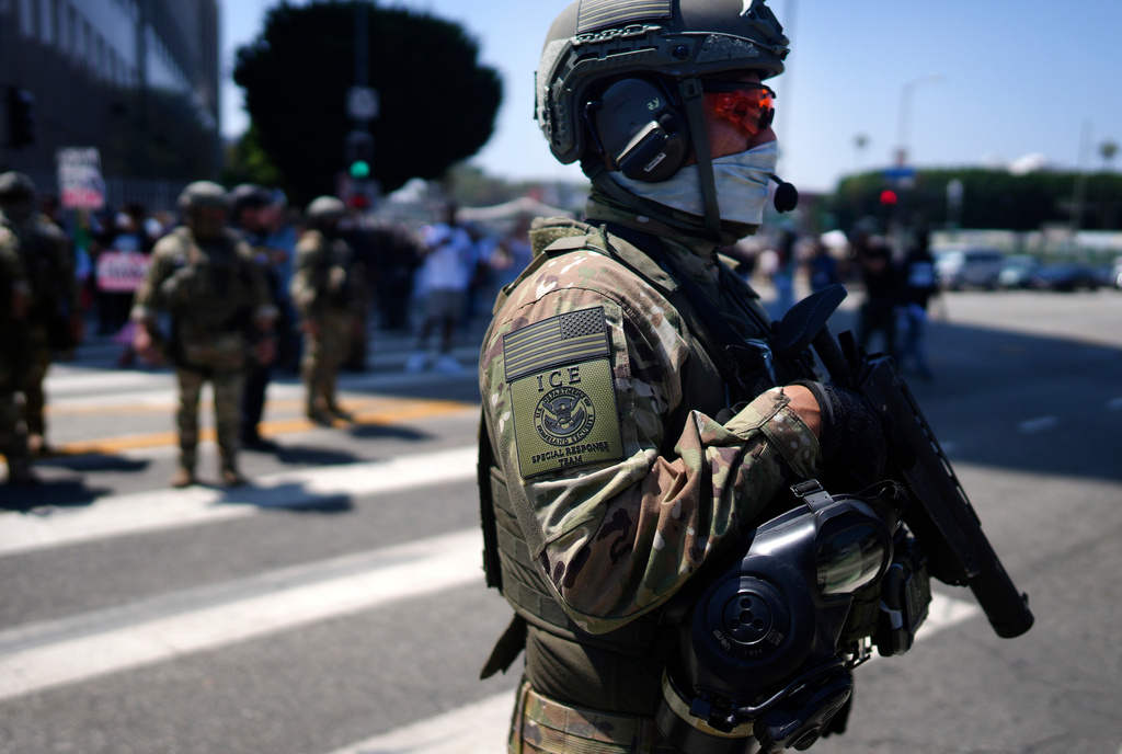 FILE - An ICE Special Response Team member stands guard outside the Metropolitan Detention Center, while protesters gather outside to denounce the ICE, U.S. Immigration and Customs Enforcement, operations, Tuesday, June 10, 2025, in downtown Los Angeles. (AP Photo/Eric Thayer, File)