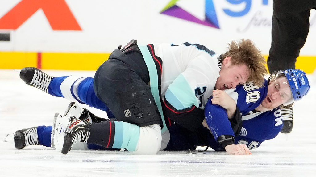 Seattle Kraken center Berkly Catton (27) and Tampa Bay Lightning defenseman J.J. Moser (90) go down while fighting during the second period of an NHL hockey game Thursday, March 26, 2026, in Tampa, Fla. (AP Photo/Chris O'Meara)