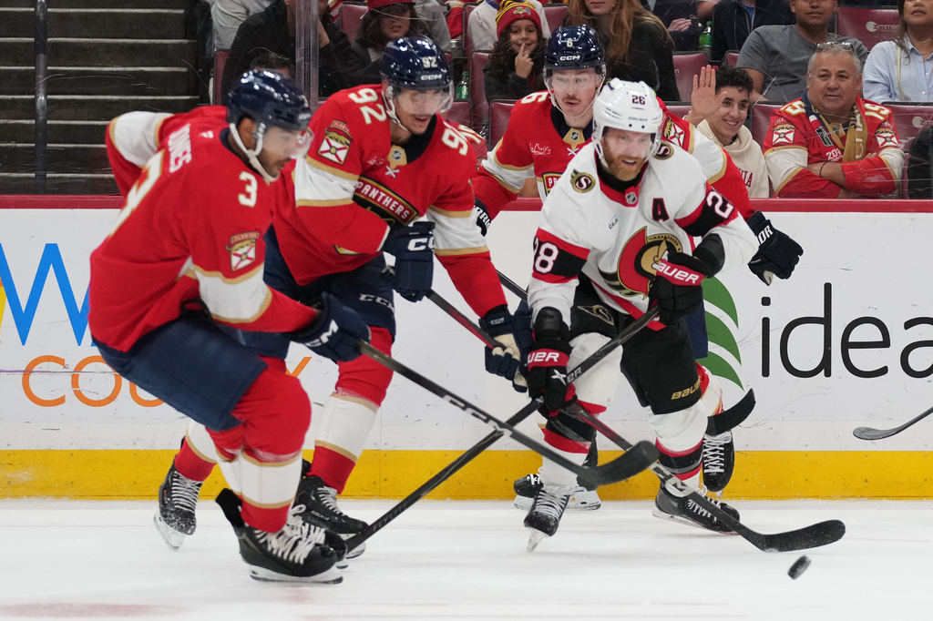 Florida Panthers defenseman Seth Jones (3), left wing Tomas Nosek (92) and Ottawa Senators right wing Claude Giroux (28) go for the puck during the first period of an NHL hockey game, Tuesday, March 31, 2026, in Sunrise, Fla. (AP Photo/Lynne Sladky)