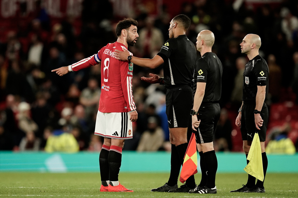 Manchester United's Bruno Fernandes, left, argues with Referee Farai Hallam at the end of the English League Cup third round soccer match between Manchester United and Brighton and Hove Albion in Manchester, England, Wednesday, Sept. 16, 2026. (AP Photo/Dave Thompson)