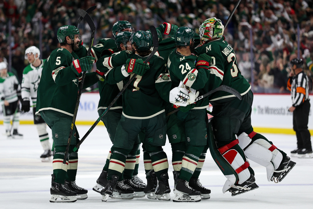 Minnesota Wild players celebrate after their team's win over the Dallas Stars during overtime of Game 4 in the first round of the NHL Stanley Cup hockey playoffs Saturday, April 25, 2026, in St. Paul, Minn. (AP Photo/Matt Krohn)