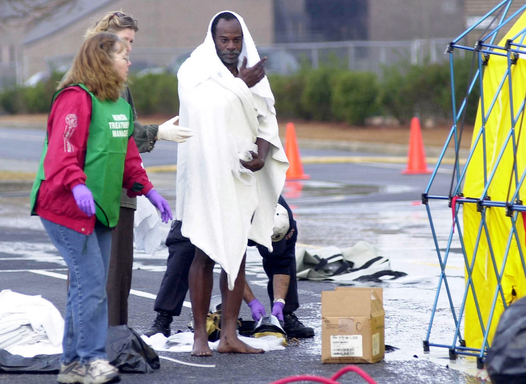 FILE - An unidentified man is helped through the decontamination process at the University of South Carolina Aiken after being exposed to chlorine gas from a train derailment in Graniteville, Jan. 6, 2005, in Aiken, S.C. (AP Photo/Mary Ann Chastain, File)