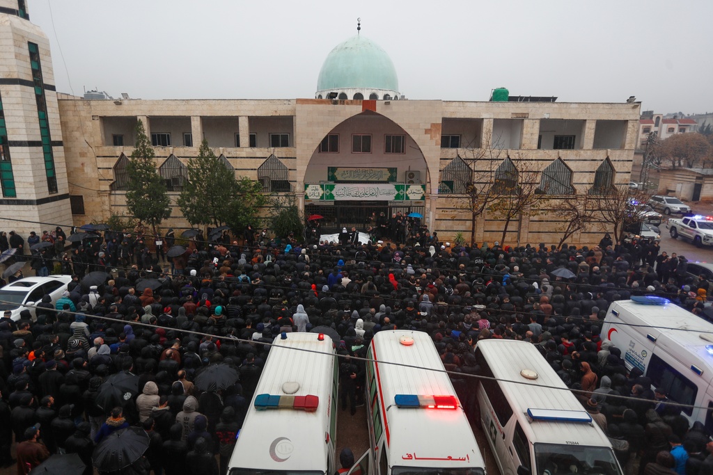 Mourners attend the funeral of victims of an attack a day earlier at the Imam Ali bin Abi Talib Mosque, outside the mosque in the predominantly Alawite Wadi al-Dhahab neighborhood of Homs, Syria, Saturday, Dec. 27, 2025. (AP Photo/Omar Sanadiki)