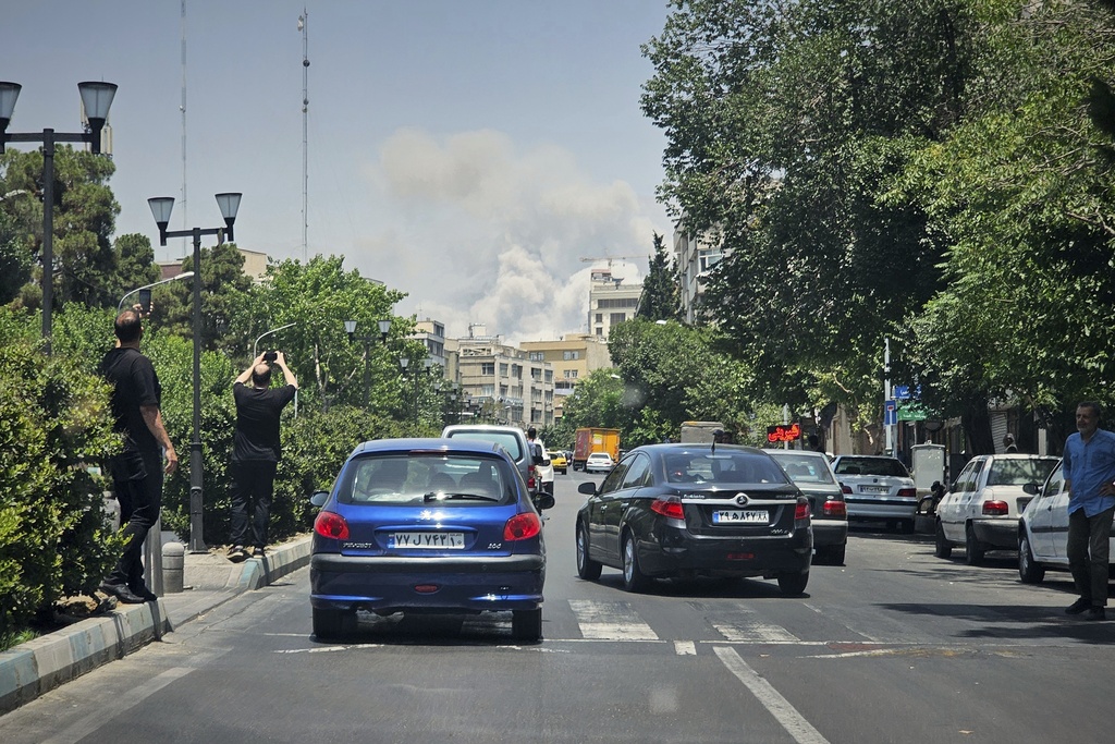 FILE - People take pictures of smoke rising from an Israeli strike in Tehran, Iran, June 23, 2025. (AP Photo, File)