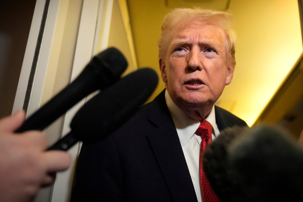 President Donald Trump speaks to reporters aboard Air Force One, Sunday, Oct. 19, 2025, en route to Joint Base Andrews, Md., as he returns from a trip to Florida. (AP Photo/Mark Schiefelbein)