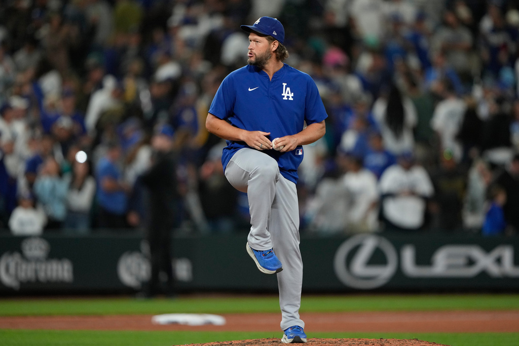 Los Angeles Dodgers starting pitcher Clayton Kershaw pretends to throw on the mound after the team's win in a baseball game against the Seattle Mariners, Friday, Sept. 26, 2025, in Seattle. (AP Photo/Ryan Sun)