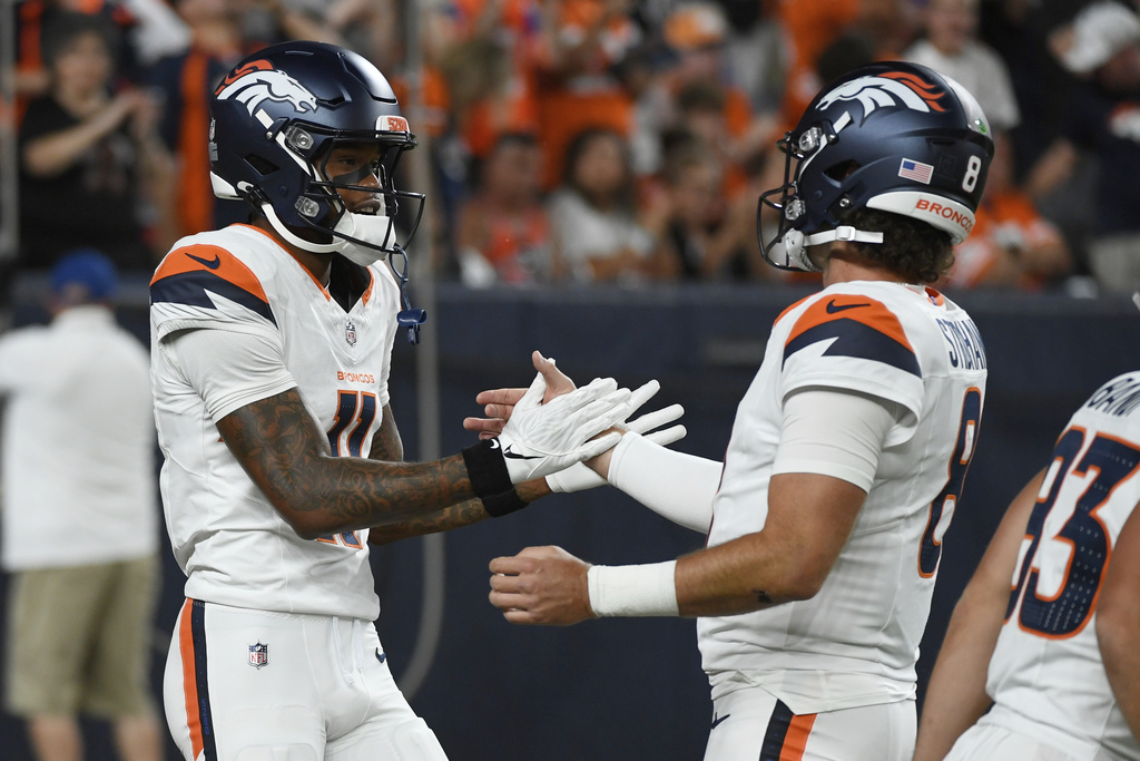 Denver Broncos wide receiver Troy Franklin (11) and quarterback Jarrett Stidham (8) celebrate after they connected for a touchdown against the Arizona Cardinals during the first half of a preseason NFL football game Saturday, Aug. 16, 2025, in Denver. (AP Photo/Eric Lutzens)