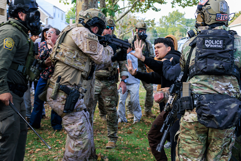 FILE - A law enforcement officer points a crowd control weapon at a protester in East Side, Chicago, Oct. 14, 2025. (Anthony Vazquez/Chicago Sun-Times via AP, File)