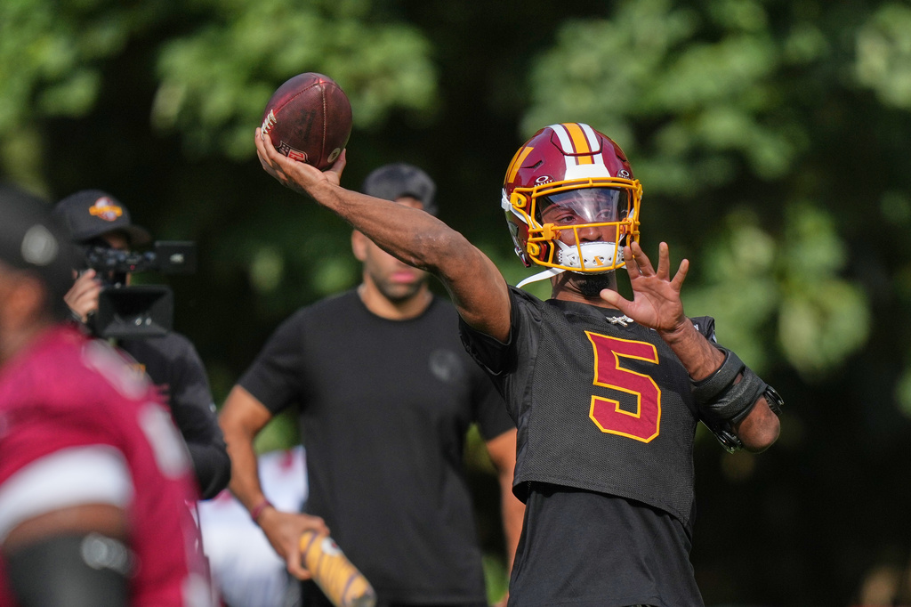 Washington Commanders' quarterback Jayden Daniels throws the ball during an NFL football practice in Hertfordshire, England, Friday, Oct. 2, 2026. (AP Photo/Alastair Grant)
