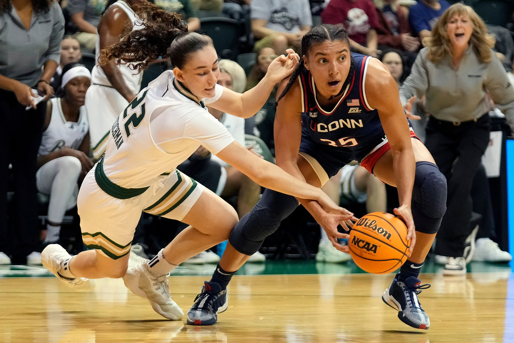 UConn guard Azzi Fudd (35) grabs the ball away from South Florida guard Lee Teichman (22) during the first quarter of an NCAA college basketball game Tuesday, Dec. 2, 2025, in Tampa, Fla. (AP Photo/Chris O'Meara)
