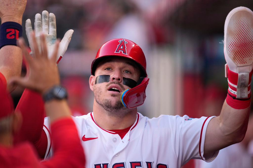 Los Angeles Angels' Mike Trout is congratulated by teammates in the dugout after scoring on a wild pitch during the second inning of a baseball game against the Colorado Rockies, Wednesday, June 3, 2026, in Anaheim, Calif. (AP Photo/Mark J. Terrill)