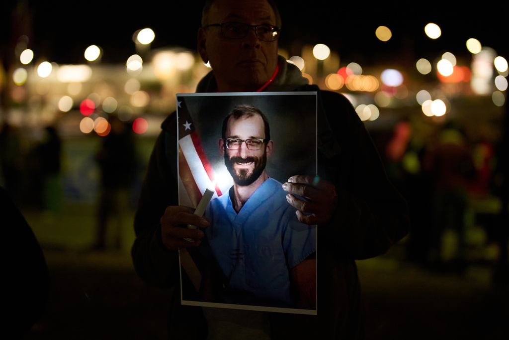 A person holds a picture during a vigil for Alex Pretti, who was shot and killed by federal immigration enforcement in Minneapolis, Wednesday, Jan. 28, 2026, in Henderson, Nev. (AP Photo/John Locher)