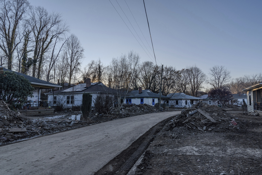 Piles of debris sit in front of homes in Swannanoa, N.C., Tuesday, Dec. 3, 2024, after damage from Hurricane Helene. (AP Photo/Stephanie Scarbrough)