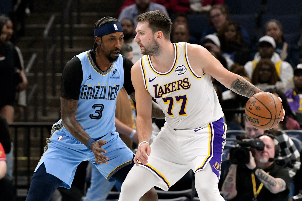 Los Angeles Lakers guard Luka Doncic (77) handles the ball against Memphis Grizzlies guard Kentavious Caldwell-Pope (3) in the first half of an NBA Cup basketball game Friday, Oct. 31, 2025, in Memphis, Tenn. (AP Photo/Brandon Dill)