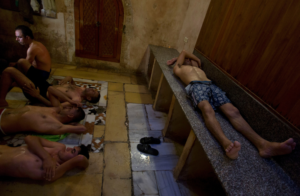 FILE - Palestinians rest outside the steam room at Hamam al-Sumara, a historic bathhouse in Gaza City, Saturday, May 2, 2015. Hamam al-Sumara means "Samaritans' Bath" in Arabic. (AP Photo/Khalil Hamra, File)