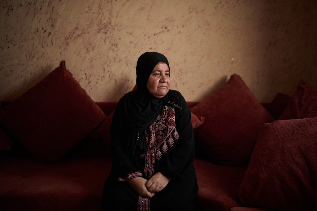 Palestinian Afaf Abu Alia, 55, who was attacked by Israeli settlers while harvesting olives in Turmus Ayya last October, poses for a photo in her home in the West Bank village of al-Mughayyir, Wednesday, Nov. 12, 2025. (AP Photo/Leo Correa)
