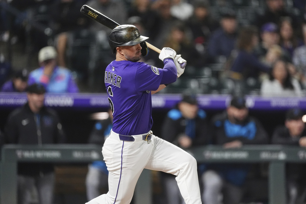 Colorado Rockies' Kyle Farmer follows the flight of his RBI single off Miami Marlins starting pitcher Ryan Weathers in the second inning of a baseball game Wednesday, Sept. 17, 2025, in Denver. (AP Photo/David Zalubowski)