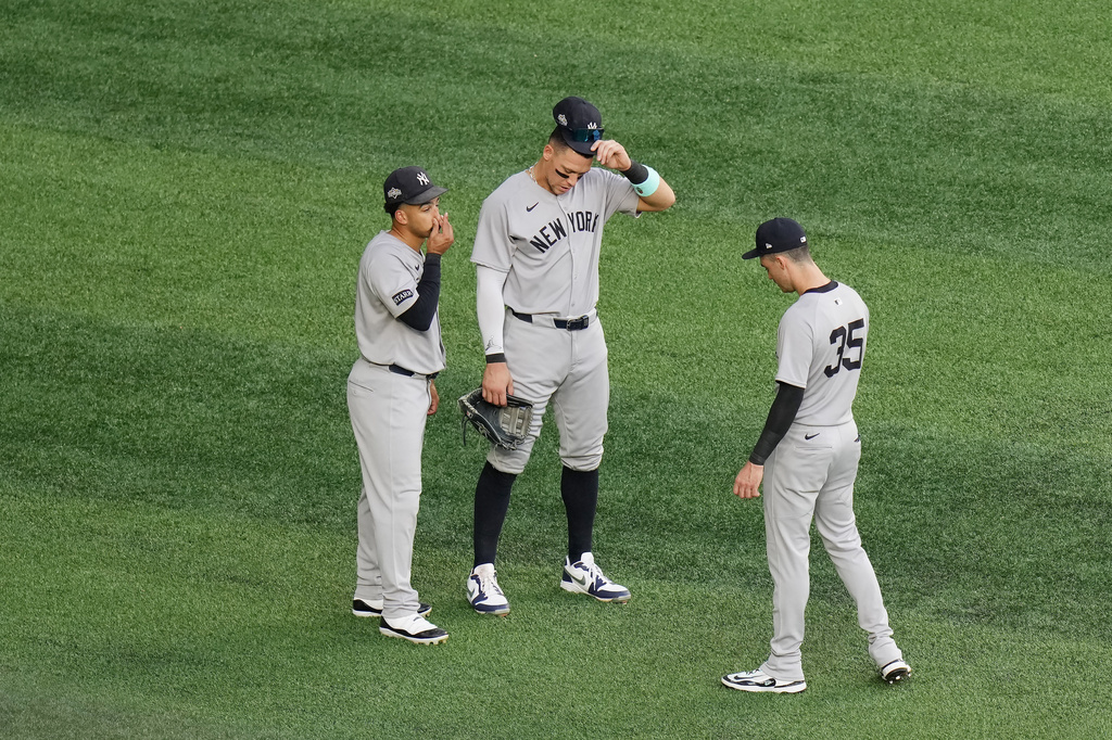 New York Yankees outfielders, from left, Trent Grisham, Aaron Judge and Cody Bellinger talk in the outfield as the Yankees make a pitching change during the third inning against the Toronto Blue Jays in Game 1 of baseball's American League Division Series, Saturday, Oct. 4, 2025, in Toronto. (Chris Young/The Canadian Press via AP)