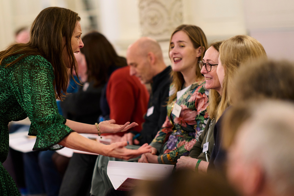 Megan Worthy, with glasses, right, and opera singer Maartje de Lint, left, and others, many of them seniors with a form of dementia, join in the "singing circle" at the Concertgebouw's ornate Mirror Hall in Amsterdam, on Feb. 24, 2026. (AP Photo/Peter Dejong)