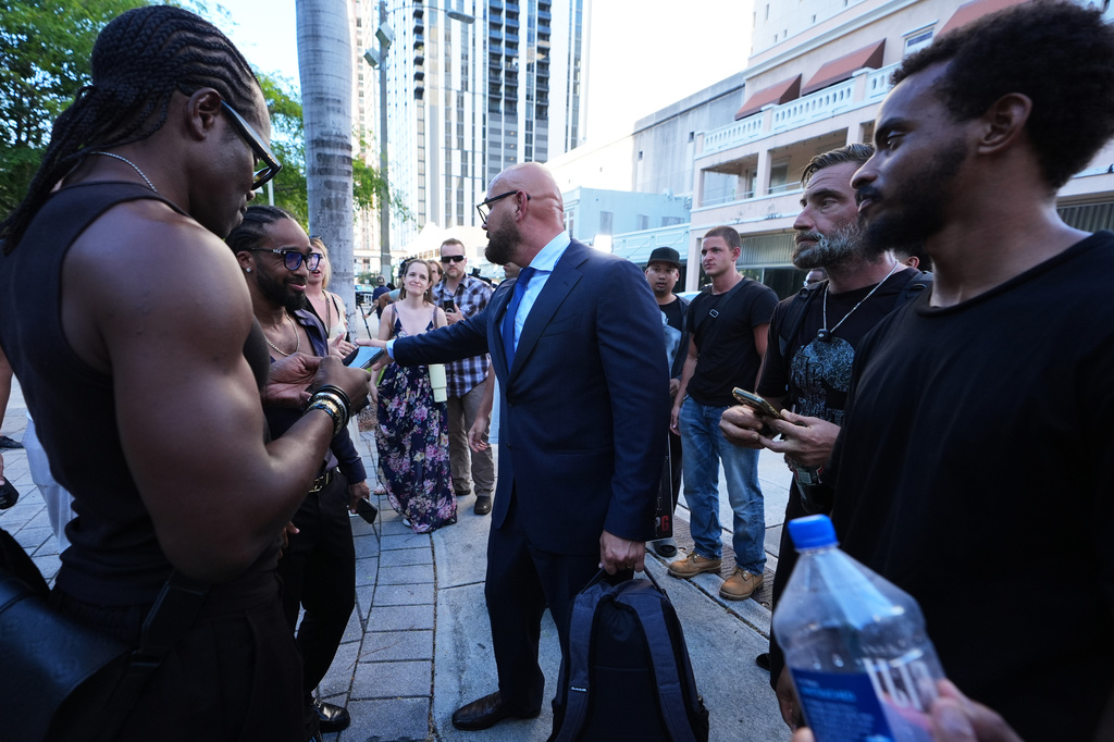 Attorney Joseph McBride, who represents Andrew and Tristan Tate as they fight extradition to the United Kingdom on charges of rape and sex trafficking, center, greets supporters of the Tate brothers after a bond hearing at the C. Clyde Atkins U.S. Courthouse, Thursday, Aug. 27, 2026, in Miami. (AP Photo/Lynne Sladky)