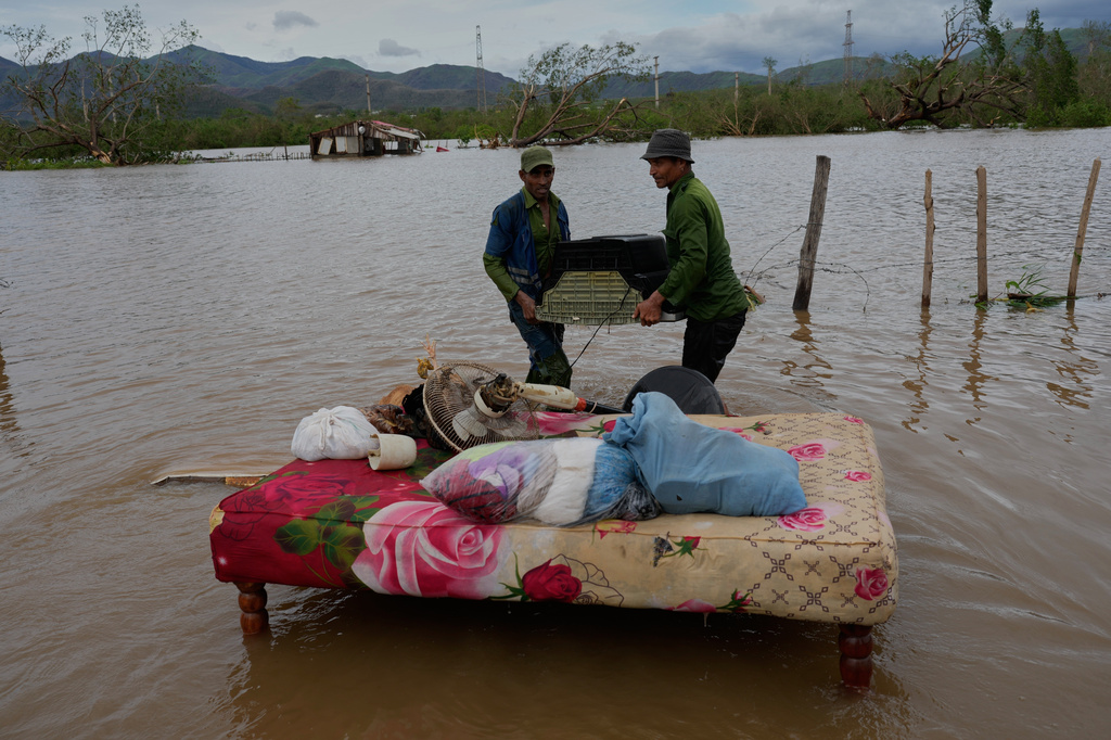 FILE - People recover belongings from a home flooded by Hurricane Melissa in Santiago de Cuba, Oct. 29, 2025. (AP Photo/Ramón Espinosa, File)