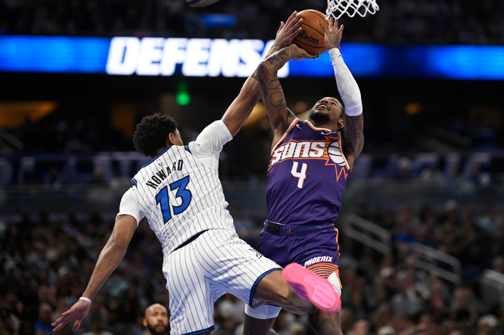 Phoenix Suns guard Jalen Green (4) goes up to shoot as Orlando Magic guard Jett Howard (13) defends during the first half of an NBA basketball game, Tuesday, March 31, 2026, in Orlando, Fla. (AP Photo/Phelan M. Ebenhack)