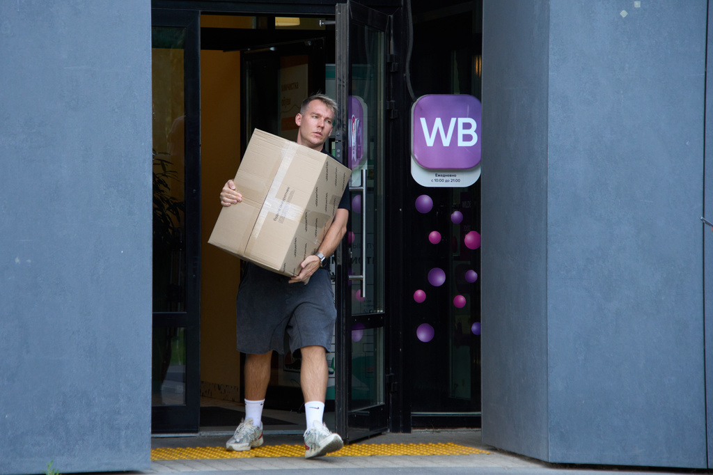 FILE - A man carrying a package leaves a pickup point for online retailer Wildberries in Moscow on Wednesday, July 22, 2026. (AP Photo/Alexander Zemlianichenko, File)