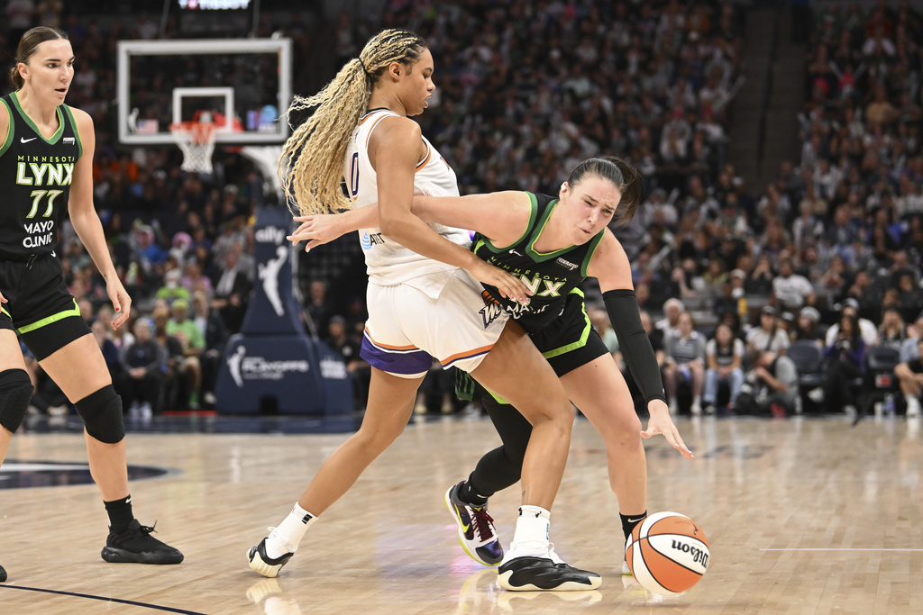 Minnesota Lynx forward Bridget Carleton, right, collides with Phoenix Mercury forward Satou Sabally (0) during the second half of Game 1 of a WNBA basketball playoff semifinals series Sunday, Sept. 21, 2025, in Minneapolis. (AP Photo/Craig Lassig)