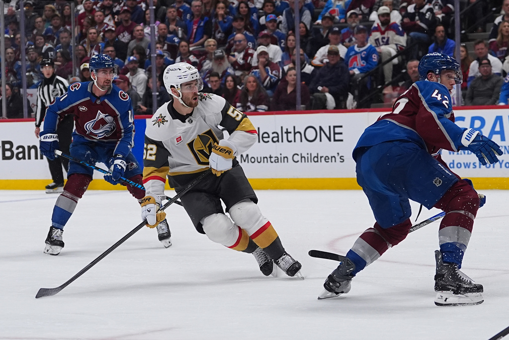 Vegas Golden Knights defenseman Dylan Coghlan, center, reacts after scoring a goal as Colorado Avalanche center Brock Nelson, left, and defenseman Josh Manson cover during the second period in Game 1 of the Western Conference finals NHL hockey Stanley Cup playoff series Wednesday, May 20, 2026, in Denver. (AP Photo/David Zalubowski)