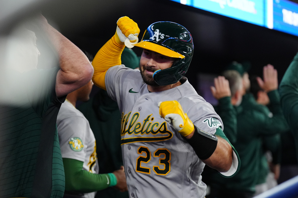 Athletics' Shea Langeliers (23) celebrates in the dugout with teammates after he hit a grand slam in the seventh inning of a baseball game against the Toronto Blue Jays in Toronto, Saturday, March 28, 2026. (Frank Gunn/The Canadian Press via AP)