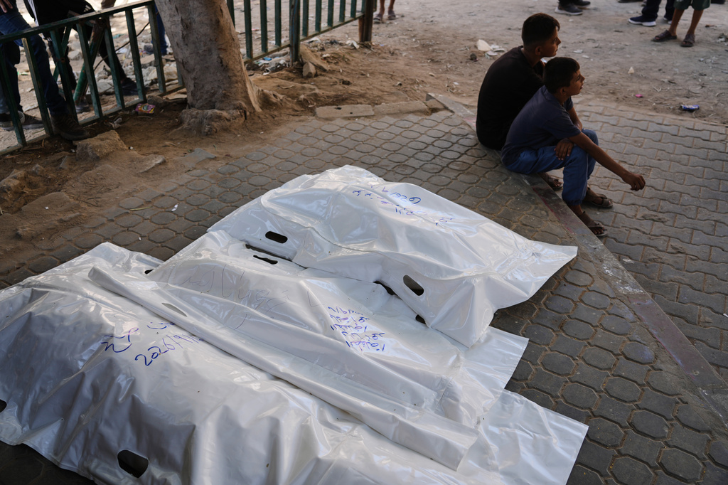 Palestinians sit beside the bodies of members of the Ahmed family, including the parents and their two children, who were killed in an Israeli army strike, at Shifa Hospital in Gaza City, Thursday, Sept. 10, 2026. (AP Photo/Jehad Alshrafi)