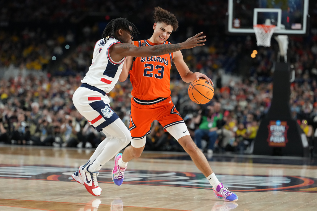 Illinois' Keaton Wagler (23) drives around UConn's Malachi Smith during the second half of an NCAA college basketball tournament semifinal game at the Final Four, Saturday, April 4, 2026, in Indianapolis. (AP Photo/Michael Conroy)