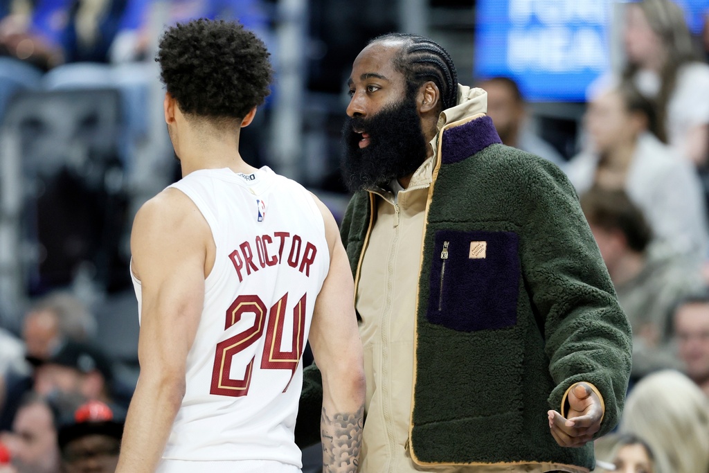 Cleveland Cavaliers guard James Harden, right, who is out injured with a right thumb fracture, talks with Cavaliers guard Tyrese Proctor (24) during the first half of an NBA basketball game Detroit Pistons, Friday, Feb. 27, 2026, in Detroit. (AP Photo/Duane Burleson)