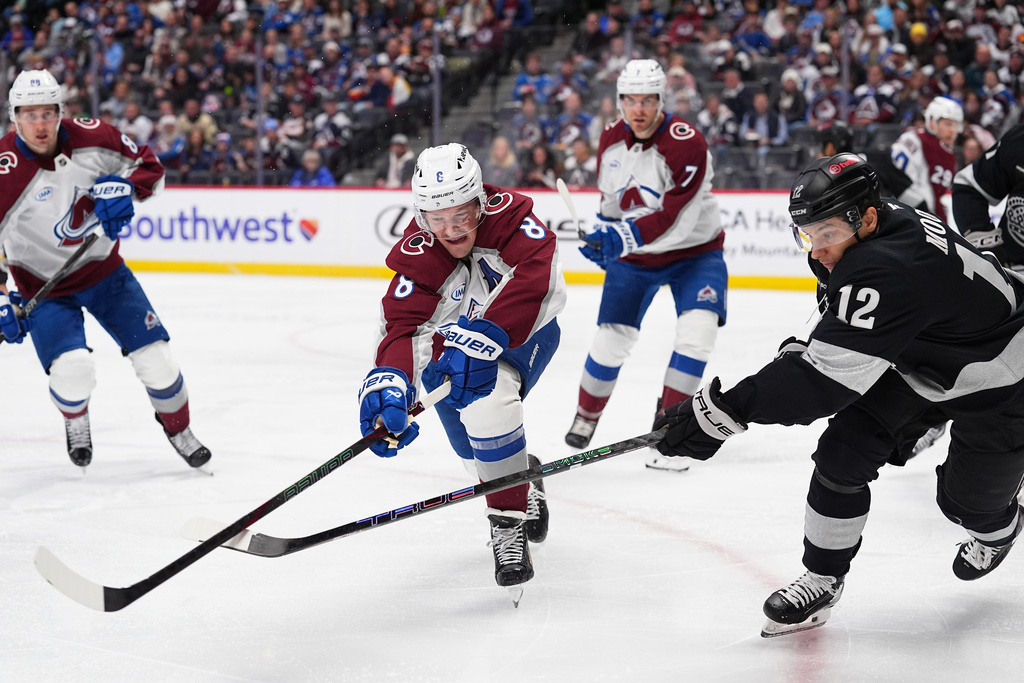 Colorado Avalanche defenseman Cale Makar, left, and Los Angeles Kings left wing Trevor Moore pursue the puck in the second period of an NHL hockey game Monday, Dec. 29, 2025, in Denver. (AP Photo/David Zalubowski)