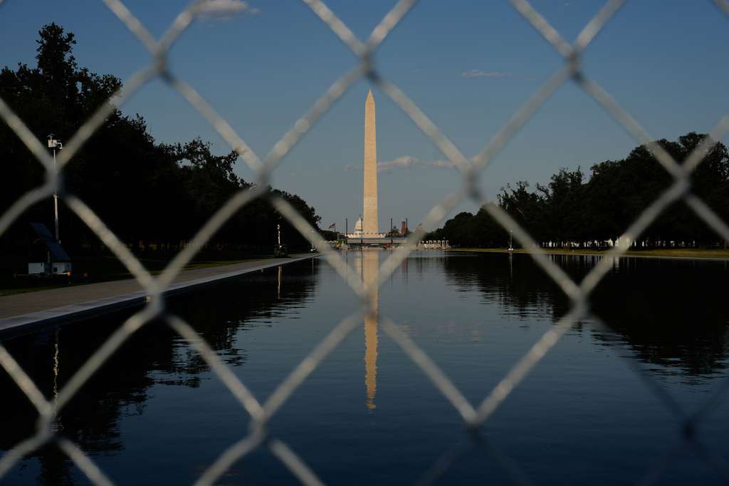 The Washington Monument, reflected in the Lincoln Memorial Reflecting Pool, is seen behind fencing, Thursday, June 25, 2026, in Washington. (AP Photo/Carolyn Kaster)