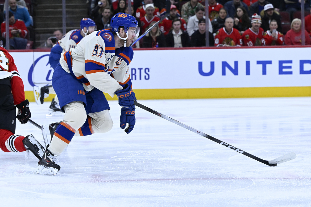 Edmonton Oilers center Connor McDavid (97) moves the puck against the Chicago Blackhawks during the first period of an NHL hockey game, Monday, Jan. 12, 2026, in Chicago. (AP Photo/Matt Marton)