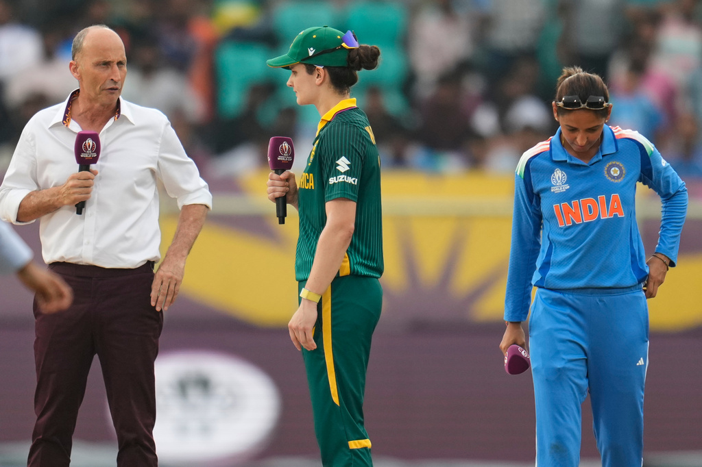 India's captain Harmanpreet Kaur, right, listens as South Africa's captain Laura Wolvaardt, center, speaks to the commentator Nasser Hussain at the toss ahead of the ICC Women's Cricket World Cup match between India and South Africa at ACA-VDCA Cricket Stadium in Visakhapatnam, India, Thursday, Oct. 9, 2025. (AP Photo/Aijaz Rahi)