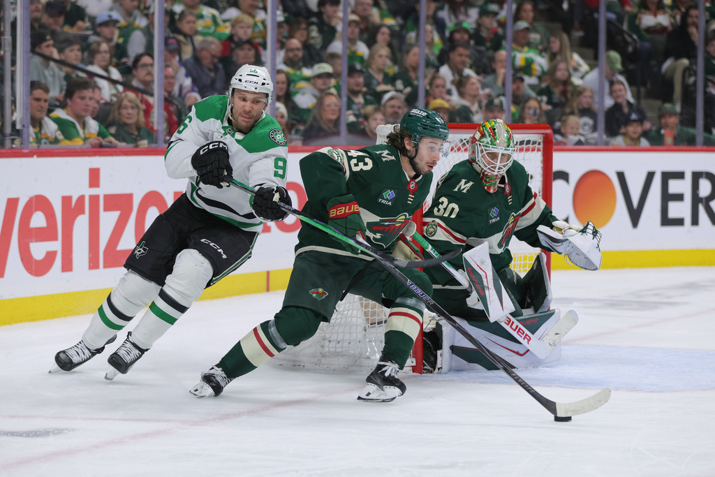 Minnesota Wild defenseman Quinn Hughes (43) skates with the puck in front of goaltender Jesper Wallstedt (30) while Dallas Stars right wing Mikko Rantanen (96) defends during the second period of Game 6 in the first round of the NHL hockey Stanley Cup playoff series Thursday, April 30, 2026, in St. Paul, Minn. (AP Photo/Bailey Hillesheim)