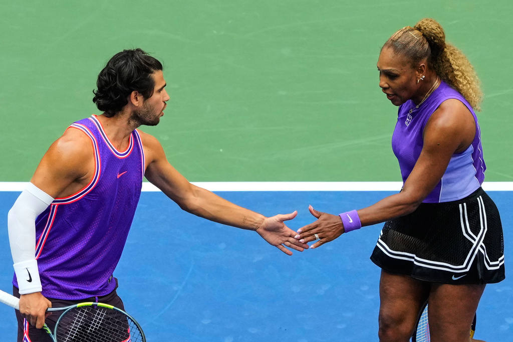 Carlos Alcaraz, of Spain, left, and Serena Williams, of the United States, high-five during a mixed doubles match at the U.S. Open tennis championships, Tuesday, Aug. 25, 2026, in New York. (AP Photo/Yuki Iwamura)