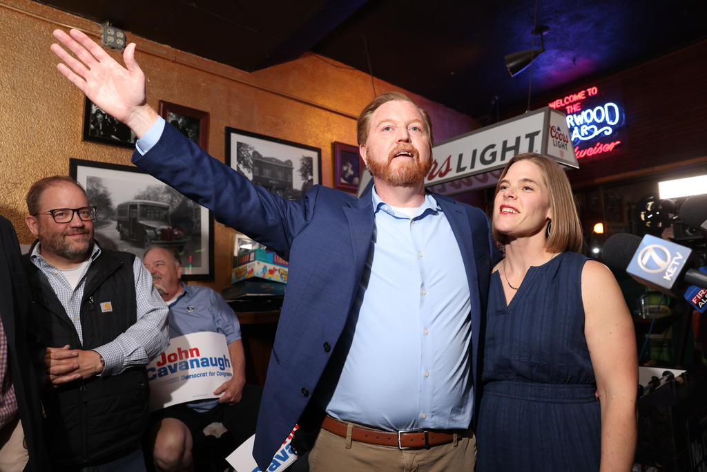 State Sen. John Cavanaugh, candidate for the Democratic nomination to the House of Representatives in Nebraska's second district, left, stands with his wife, Kakie McGill, during an election night watch party Tuesday, May 12, 2026, in Omaha, Neb. (AP Photo/Rebecca S. Gratz)