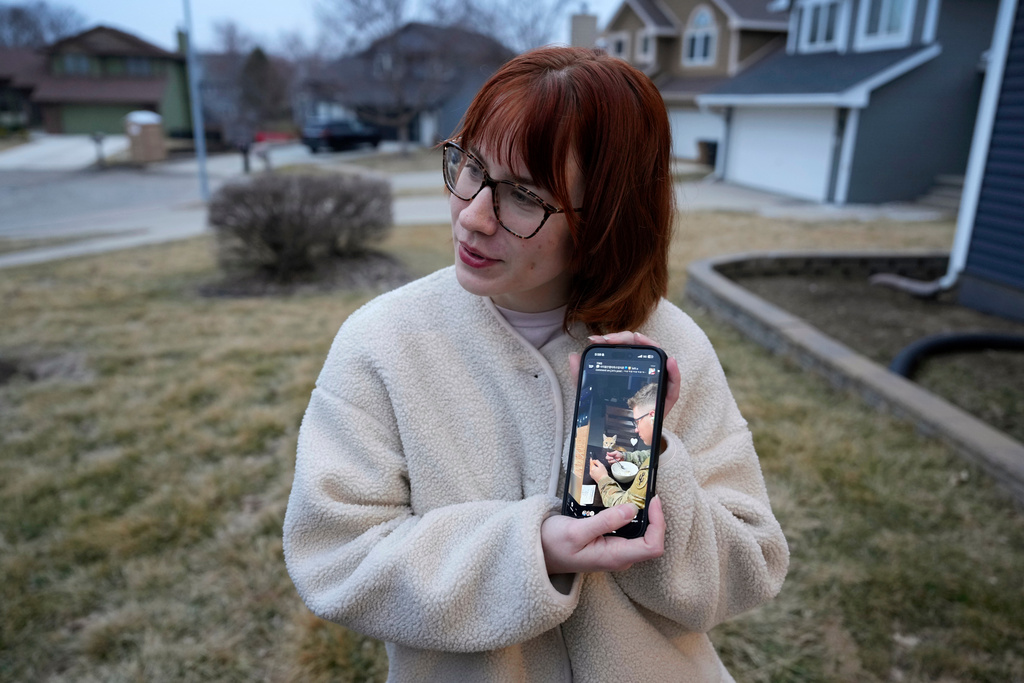 Keira Coady holds a photo of her brother, Sgt. Declan Coady, 20, of West Des Moines, Iowa, outside her home, Tuesday, March 3, 2026, in West Des Moines, Iowa. (AP Photo/Charlie Neibergall)
