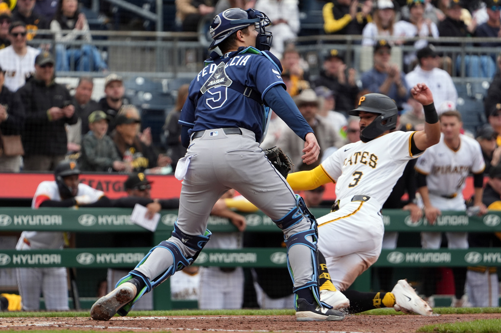 Pittsburgh Pirates' Nick Gonzales, right, slides past Tampa Bay Rays catcher Hunter Feduccia, left, to score on Pirates' Bryan Reynolds' two-run single in the fifth inning of a baseball game in Pittsburgh, Sunday, April 19, 2026. (AP Photo/Tom E. Puskar)